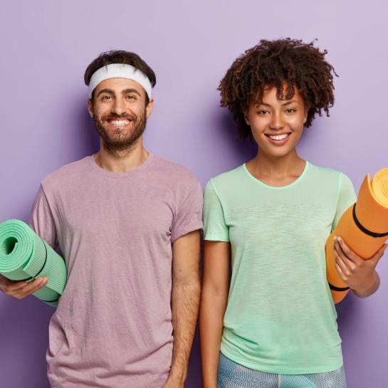 Foto van twee mensen met een yogamat onder de arm